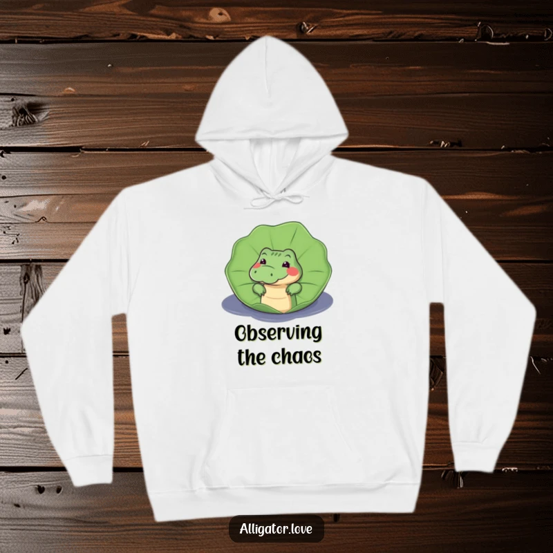 Funny hoodie featuring a curious alligator peeking from behind a large lily pad, conveying a sense of playful mystery.